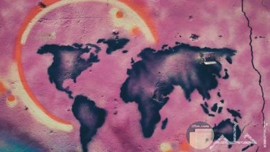 صورة غريبة وجميلة لخريطة الكرة الأرضية مرسومة علي حائط بخلفية ورديه