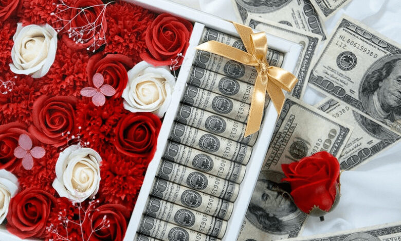 صورة باقة ورد حمراء مع نقود دولارات كثيرة في بوكس هدايا